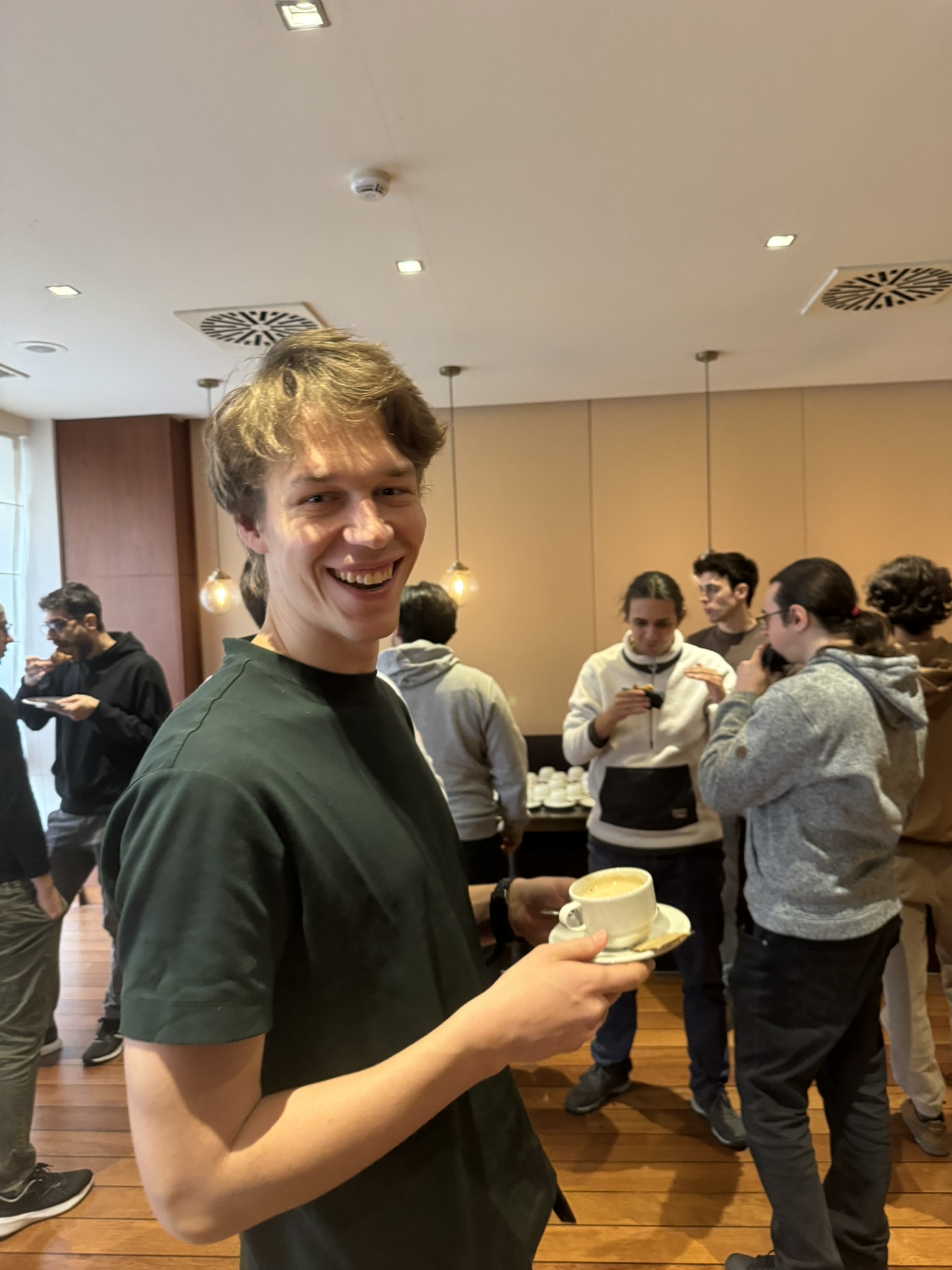 Coffee break offered by Tigerbeetle during the morning, with Marek smiling while holding a coffee